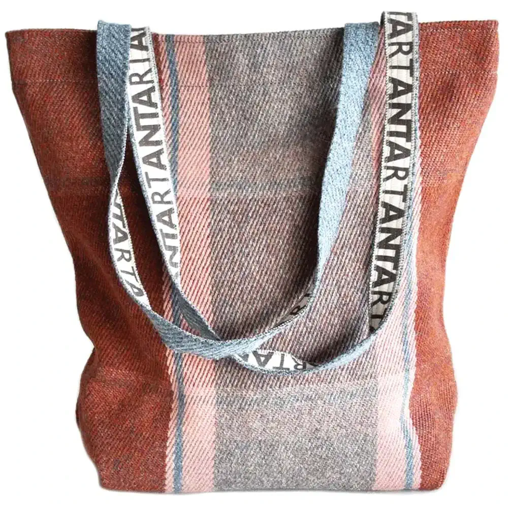 Tartan tote bag in muted red, grey, and blue with woven straps.